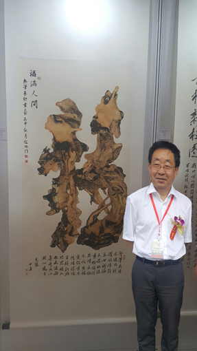 第二届“古建与书画之美”作品展活动中中国民族建筑研究会会长、国家民委计划财务司司长李春林在杨继林老师作品前留影